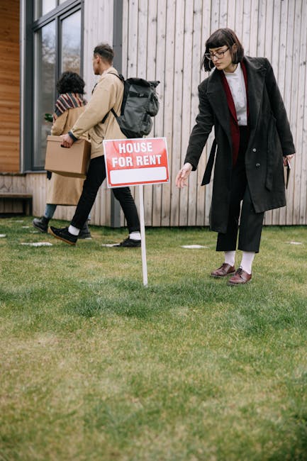 A group of adults inspecting a house for rent sign outside an apartment building while moving in.